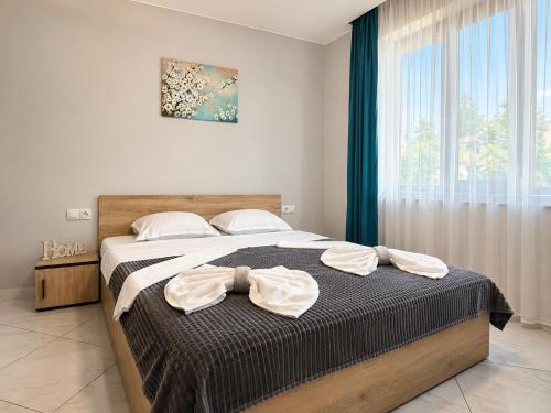 a bedroom with a bed with two towels on it at Къща за гости ЕМ Парадайс 2 in Tserova Koriya