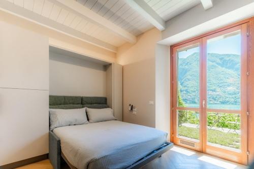 a bedroom with a bed and a large window at Lakeside Garden Studio in Laglio