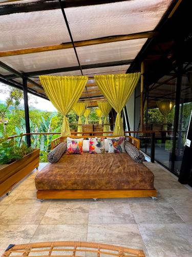 a bedroom with a large bed on a patio at Suites Casa ColibrÍ in Mindo
