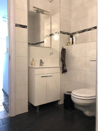a white bathroom with a toilet and a sink at Sweethome - Köln Messe in Bergisch Gladbach