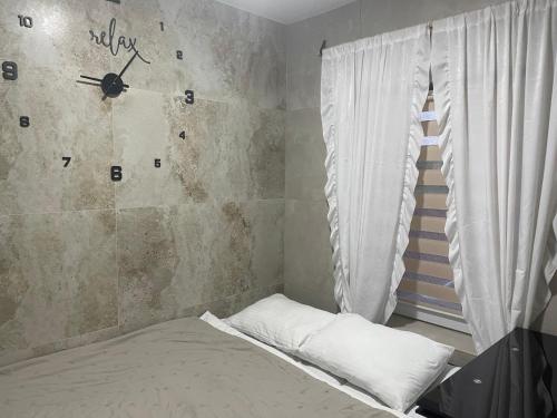 a bedroom with a clock on the wall and a bed at AmurRelaxCreative in Khmelnytskyi