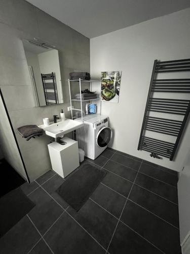 a bathroom with a sink and a washing machine at Ferienwohnung zum Kriegerdenkmal in Alzey