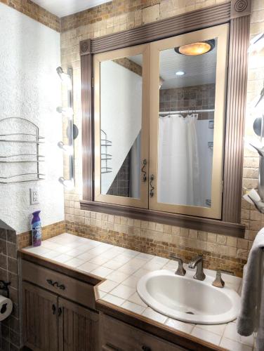 a bathroom with a sink and a mirror at Serenity Sands Cayman in Bodden Town