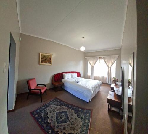 a bedroom with a white bed and a chair at Oolele BnB Newcastle in Newcastle