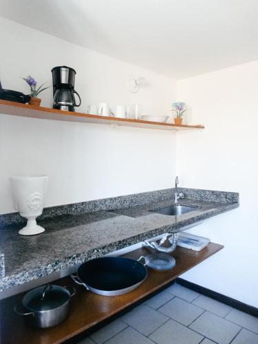 a kitchen counter with a sink and pots and pans at Viva Buzios in Búzios