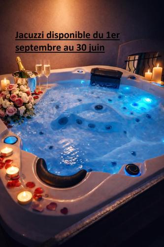 a jacuzzi tub in a room with candles at Echappée verte avec piscine et clim proche de Paris in Vert-le-Grand