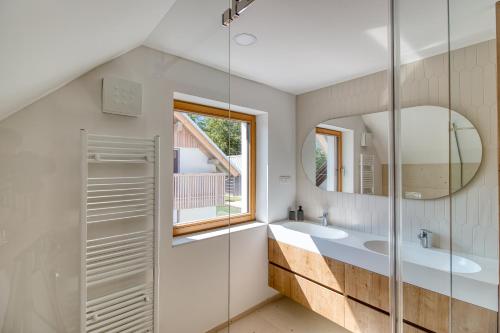 a bathroom with two sinks and a mirror at Bohinj Rentals Twin Villas in Bohinj