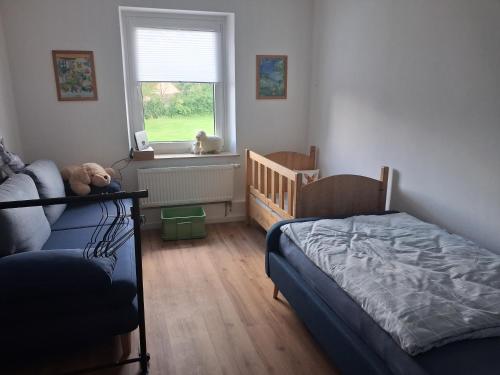 a bedroom with a bed and a crib and a window at Landliebe in Blomberg