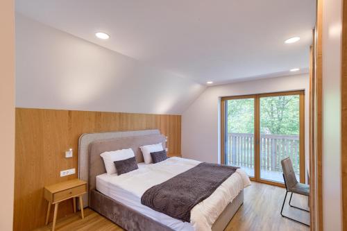 a bedroom with a large bed and a balcony at Bohinj Rentals Twin Villas in Bohinj