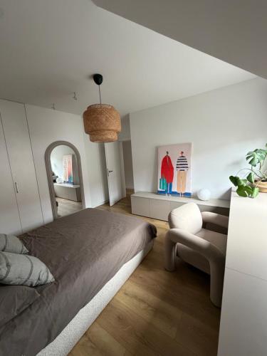 a bedroom with a large bed and a chair at Dom nad jeziorem in Ostróda