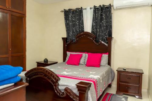 a bedroom with a large bed with pink pillows at 3 dormitorios y confortable apartamento in Santo Domingo