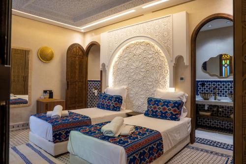 a room with two beds with blue and white at Riad Secret Mahjouba in Marrakesh