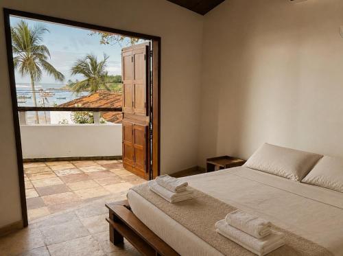 a bedroom with a bed and a view of the ocean at Casaboa Casarão Boutique Orla in Itacaré