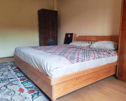 a bed with a wooden frame in a bedroom at Vila close to Bran Castle in Moieciu de Jos