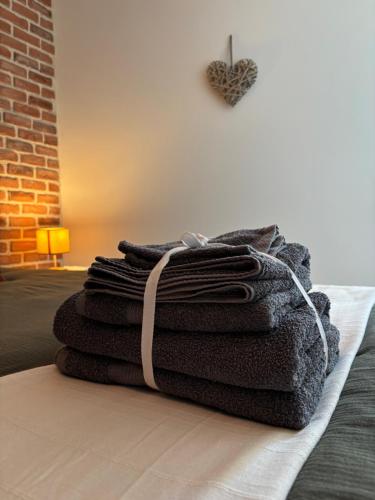a stack of towels sitting on top of a bed at Le cocon d Albi in Albi