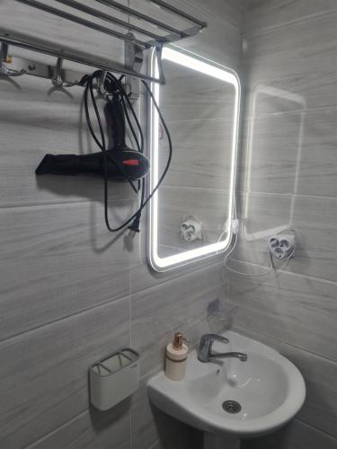 a bathroom with a sink and a mirror at Diona Raduga West in Koshkolʼ