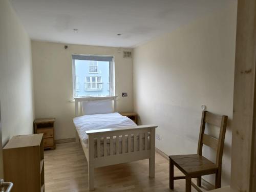 a bedroom with a bed and a chair and a window at Salthill Gem in Galway