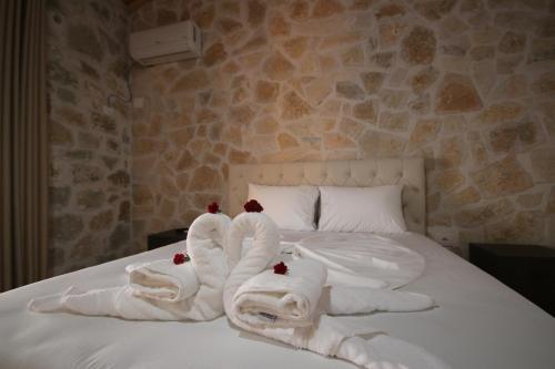 a bed with white towels and red roses on it at Villa ACROPOLIS in Jal