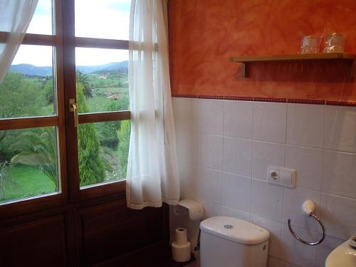 łazienka z toaletą i oknem w obiekcie Casa Torreteyera w mieście Villaviciosa