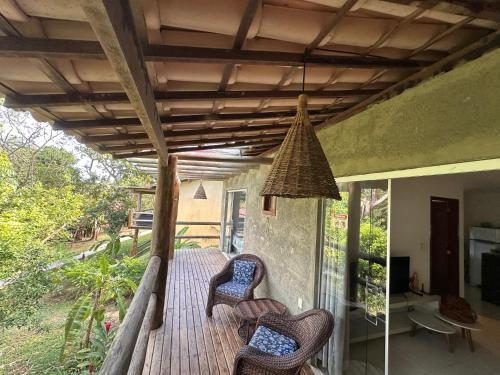 a porch with chairs and a pendant light at Bangalô com Quarto, Sala, Varanda in Maceió