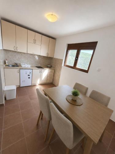 a kitchen with a wooden dining table and chairs at Darinka in Ulcinj