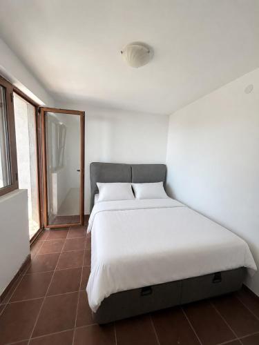 a bedroom with a large bed with white sheets at Darinka in Ulcinj