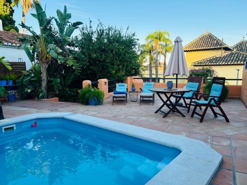 a patio with a pool and a table and chairs at Apartamento con jacuzzi y terraza con opcion a Piscina Privada in Almuñécar