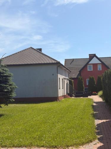 a garage in a yard with houses in the background at Słoneczne Ranczo Rowy in Rowy