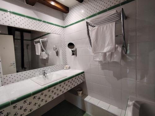 a white bathroom with a sink and a mirror at Villa Ric in Saint-Céré