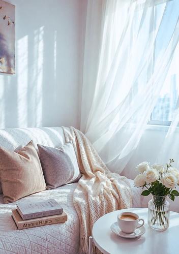 a living room with a couch and a table with a cup of coffee at The Lumière Stays Cozy Mallside Boutique Haven in Trece Martires