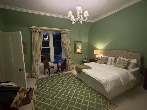 a green bedroom with a bed and a window at Newton Farmhouse B & B in Jedburgh