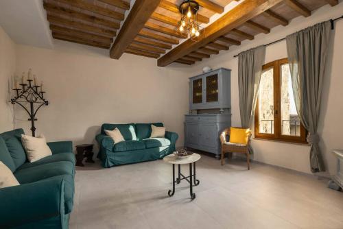 a living room with two green couches and a table at Casa Costarella - San Gimignano in San Gimignano