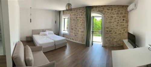 a bedroom with two beds and a living room at Milo's Villa in Dhërmi
