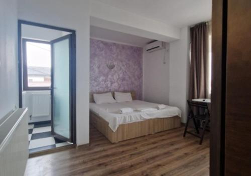 a bedroom with a bed and a large mirror at Harmony Rooms & Studios in Constanţa