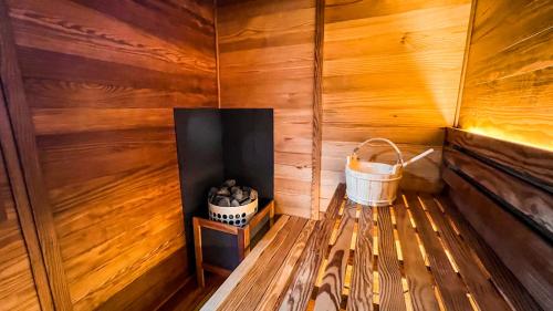 a wooden sauna with a bucket on a table at Tokyo Sake House in Ome