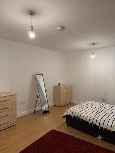 a bedroom with a bed and a dresser and a mirror at Central 2 bed large apt M1 area in Manchester