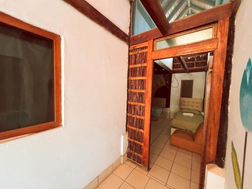 ein Zimmer mit einer Tür, die zu einem Schlafzimmer führt in der Unterkunft La Posada in Máncora