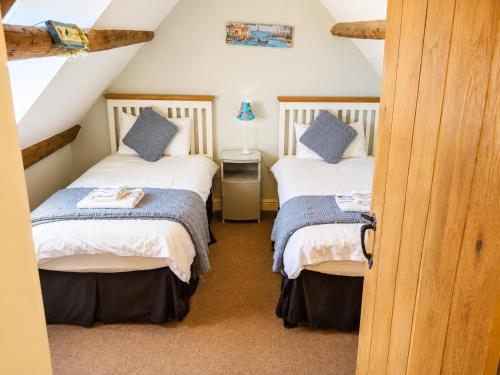 a attic room with two beds with blue pillows at Whitby Sea View Cottage Prime Historic Old Town Location in Whitby