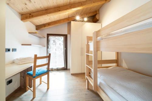 a bedroom with two bunk beds and a desk at Césa Marta in Canazei