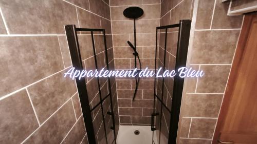 a shower in a bathroom with brown tiles at La Maison de l'horloge in Bagnères-de-Bigorre