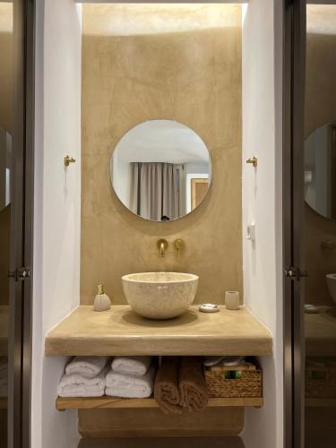 a bathroom with a bowl sink and a mirror at Pyrgianos Suites - Private Jacuzzi in Glinado Naxos