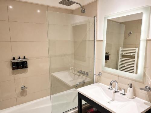 ein Badezimmer mit Dusche, Waschbecken und Badewanne in der Unterkunft AC Suites in Puerto Madryn