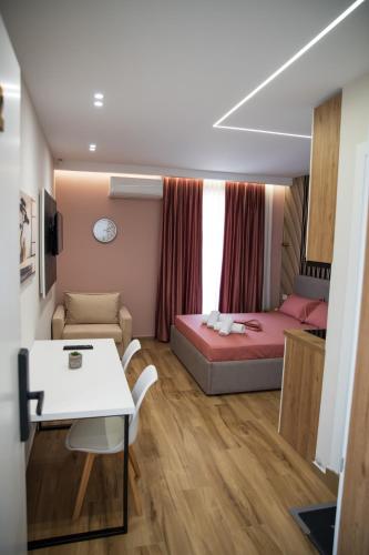 a small room with a bed and a table at Hersol Skyline in Durrës