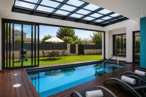 a swimming pool in a house with a glass ceiling at Gira-sol Planetcostadorada in Cambrils