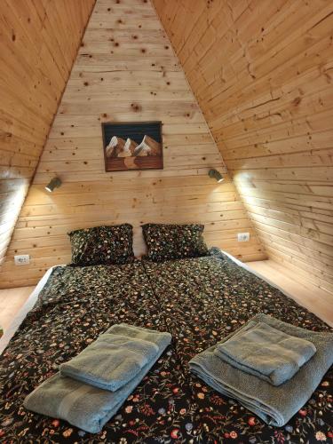 a bedroom with a bed in a wooden attic at Transylvantures Cabin in Rimetea