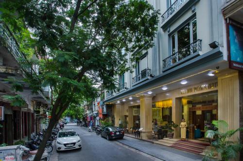 a city street with cars parked in front of buildings at Hanoi Pearl Hotel in Hanoi