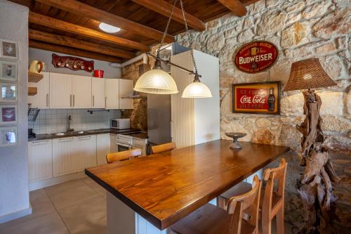a kitchen with a wooden table in a room at Forest stone Villa with pool in Kriopigi