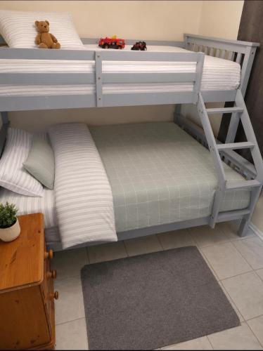 two bunk beds with pillows and a teddy bear on top at Chalet 85 in Caeathro