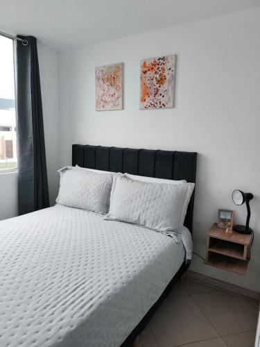a bed with a black headboard in a bedroom at Faro 2 Loft Jaime Duque, Autódromo Tocancipá in Tocancipá