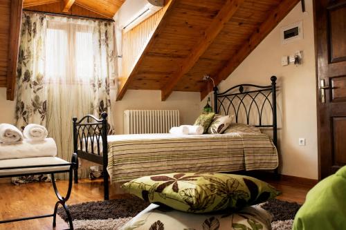 a bedroom with a bed and a wooden ceiling at Filyra Pension in Nafplio